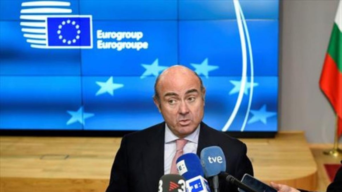 Luis de Guindos atiende a la prensa ayer, en Bruselas, tras la reunión del Eurogrupo.-/ AFP / JOHN THYS