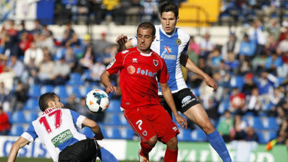 Julio Álvarez ve como el gigantón Yuste despeja un balón. / ÁREA 11-