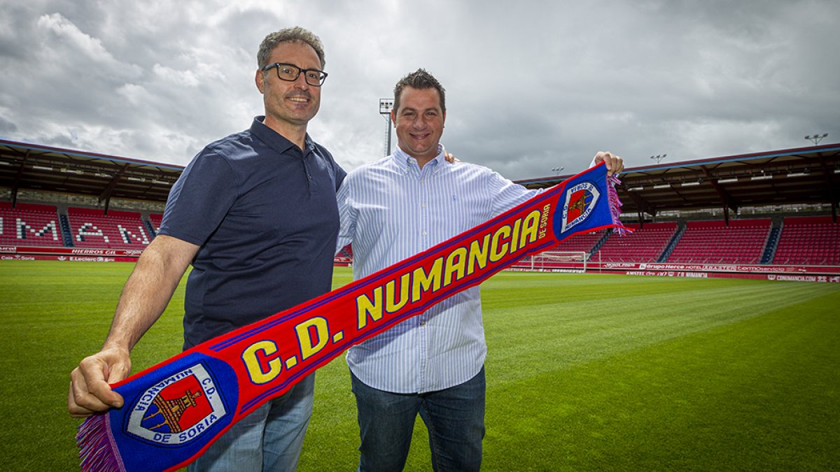 rturo Guerra y Diego Martínez posan con la bufanda del Numancia sobre el césped de Los Pajaritos. MARIO TEJEDORA