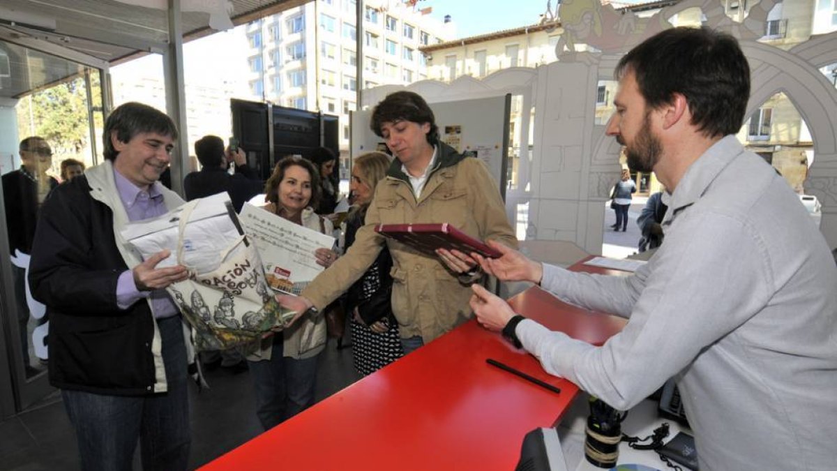 Catatalina Castela, en el centro, recoge de manos del alcalde el diploma acreditativo de turista número uno en la nueva oficina.-VALENTÍN GUISANDE