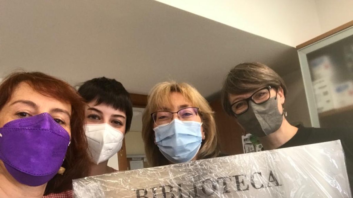 Varias compañeras de Manuel Villar Raso sostienen el letrero que, desde este jueves, dará nombre a la biblioteca. HDS