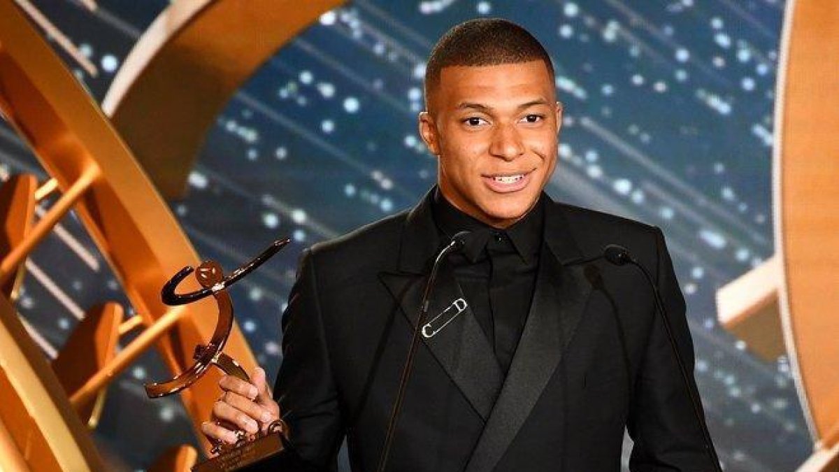Mbappe posa con el trofeo como mejor jugador de la temporada en Francia.-AFP