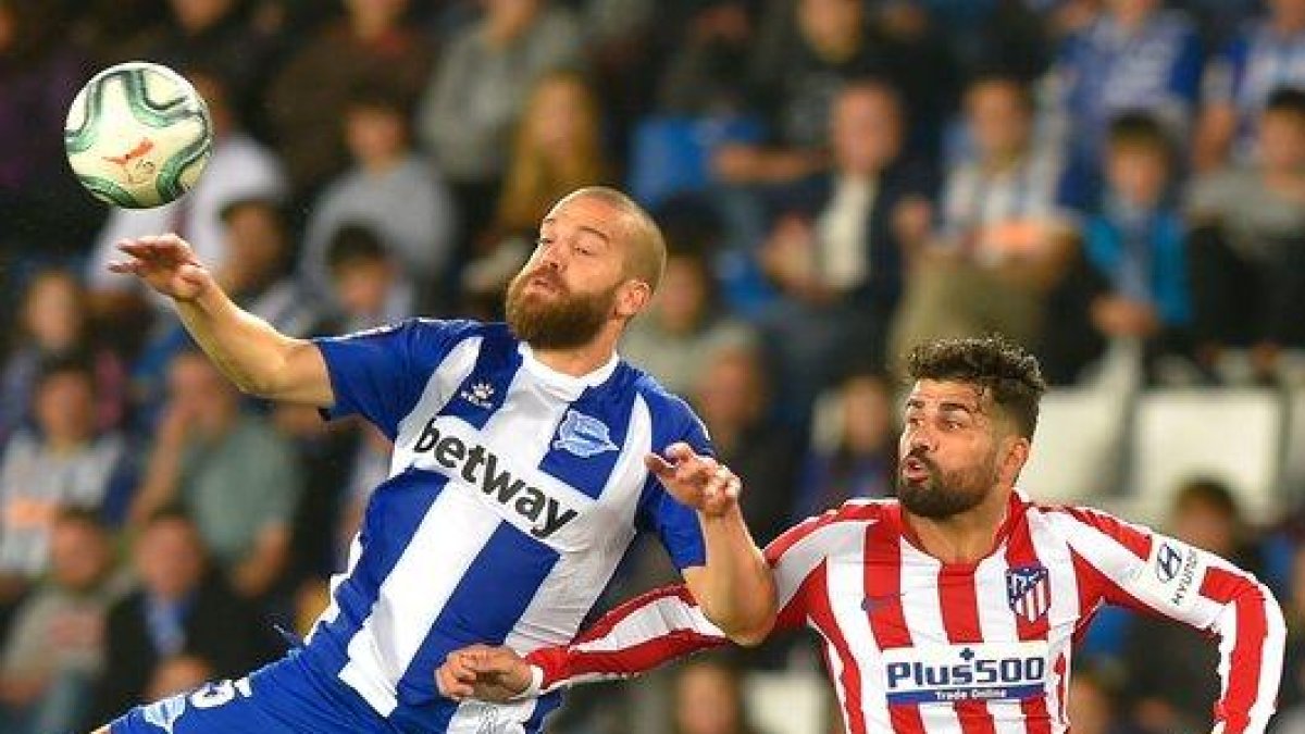 El atlético Diego Costa disputa un balón aéreo ante Laguardia en el partido ante el Alavés.-AFP
