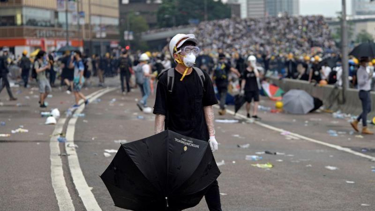 Un protestante porta un paraguas durante las manifestaciones masivas contra la polémica ley de extradición, este miércoles en Hong Kong (China).-EFE/ VERNON YUEN