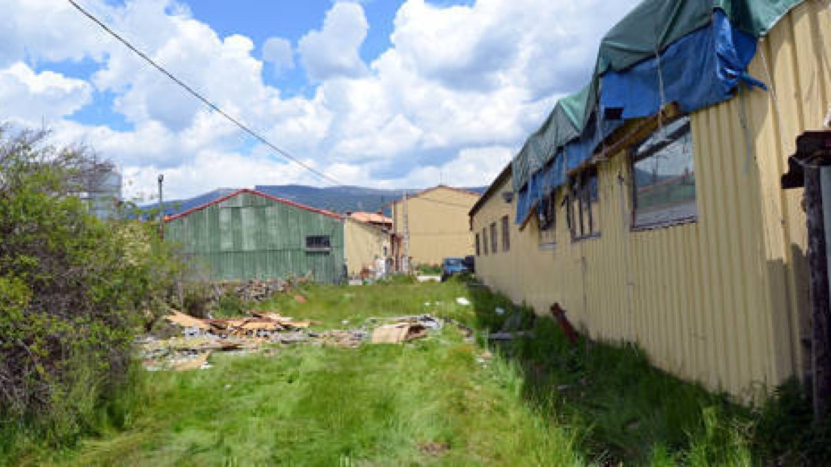 Restos de la techumbre junto a la nave afectada, ya cubierta por una lona. / RAQUEL FERNÁNDEZ-
