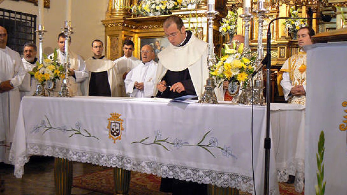 Fray David firma en el altar de la Iglesia del Carmen la cédula de profesión después de las letanías. / ÍÑIGO SALINAS-