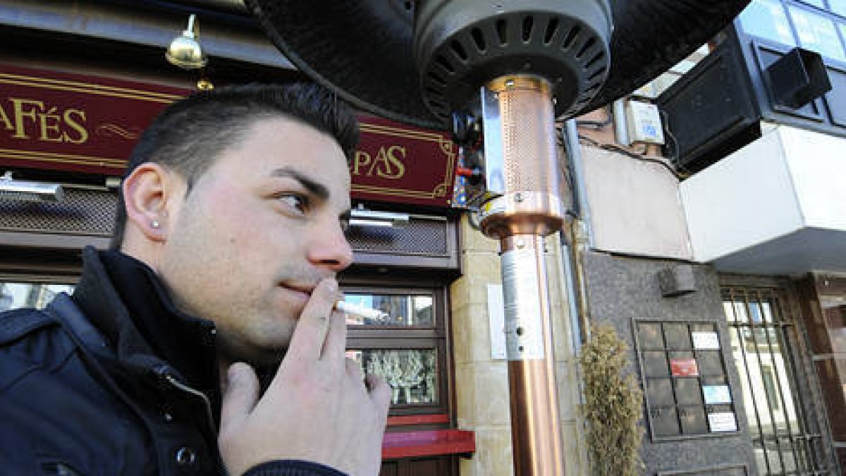 Un joven fuma ayer en la puerta de un establecimiento soriano. / VALENTÍN GUISANDE-
