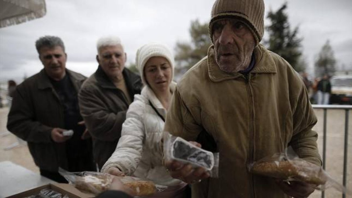 Ciudadanos griegos hacen cola para recibir alimentos con motivo de la celebración del 'Lunes Limpio', este lunes en Atenas.-Foto: EFE / YANNIS KOLESIDIS