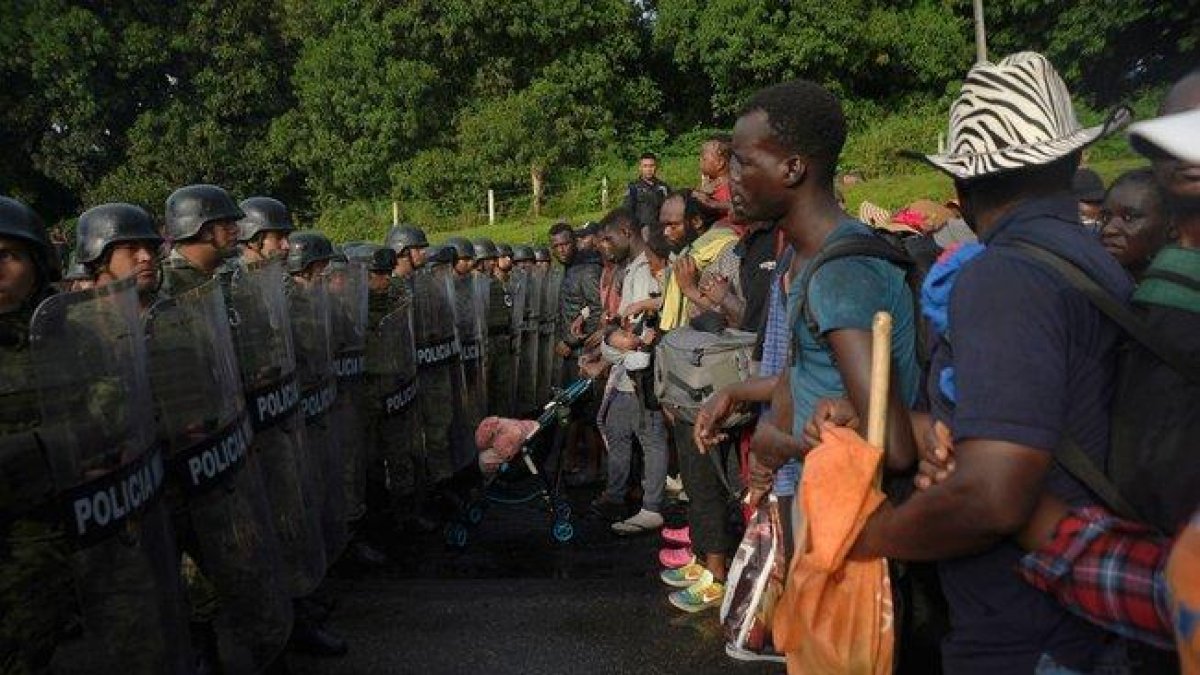 Elementos de la Guardia Nacional, policías federales y personal del Instituto Nacional de Migración (INM) detienen la marcha de unos 2.000 migrantes.-EFE