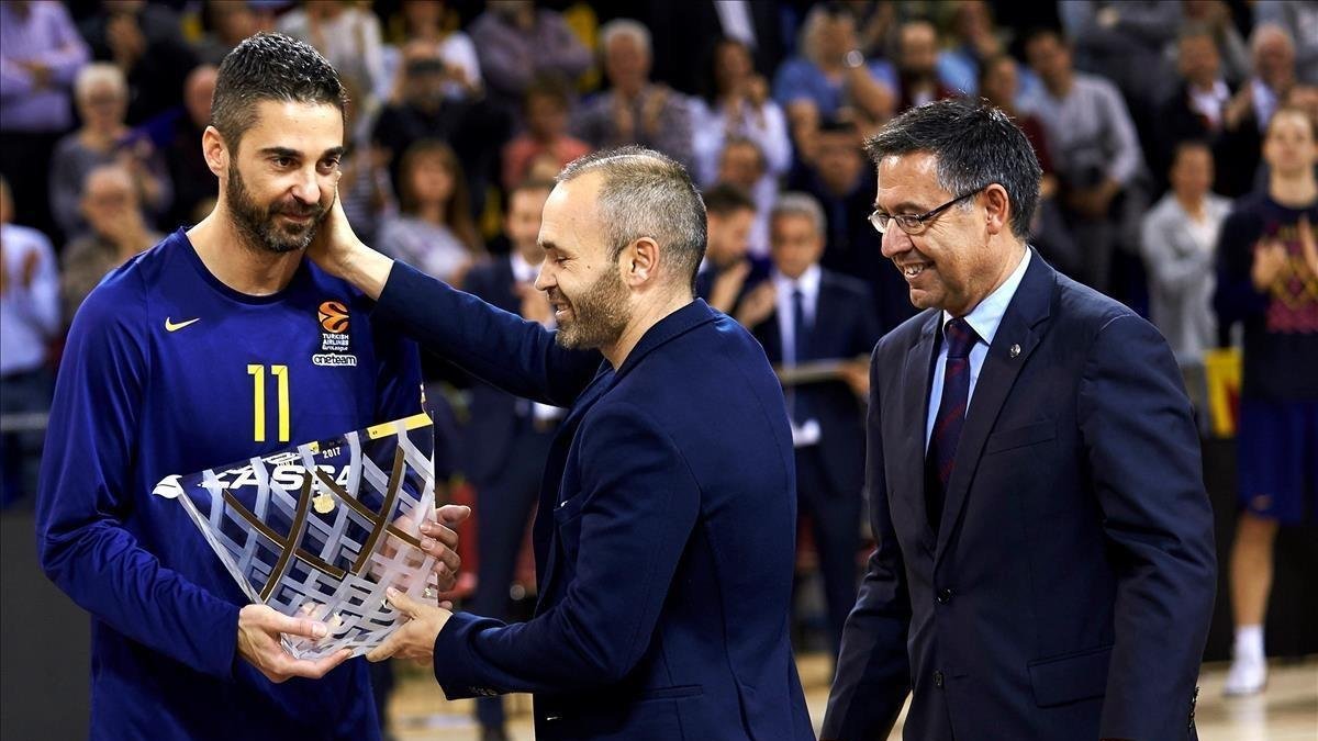 Navarro recibe una placa de manos de Iniesta y el presidente Bartomeu durante el homenaje por sus 20 años como azulgrana a finales del 2017 /-ALEJANDRO GARCIA (EFE)