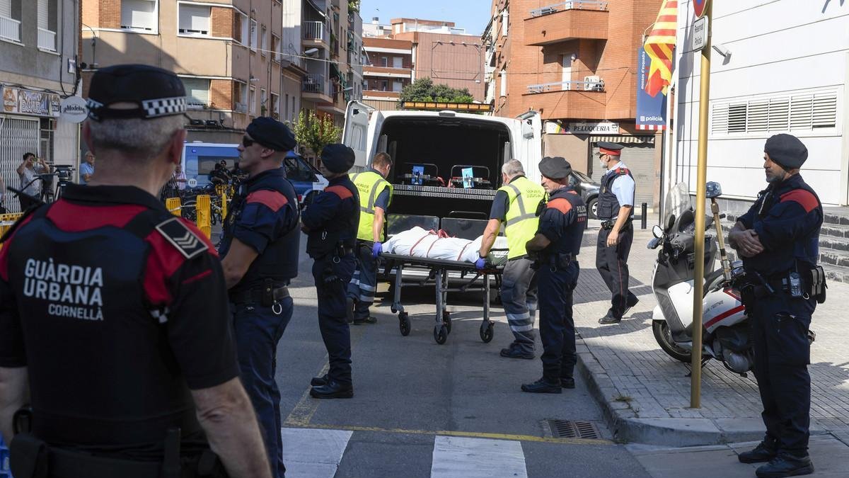 Miembros de la funeraria judicial retiran el cadáver del agresor de la comisaría de los Mossos en Cornellà. /-JORDI COTRINA
