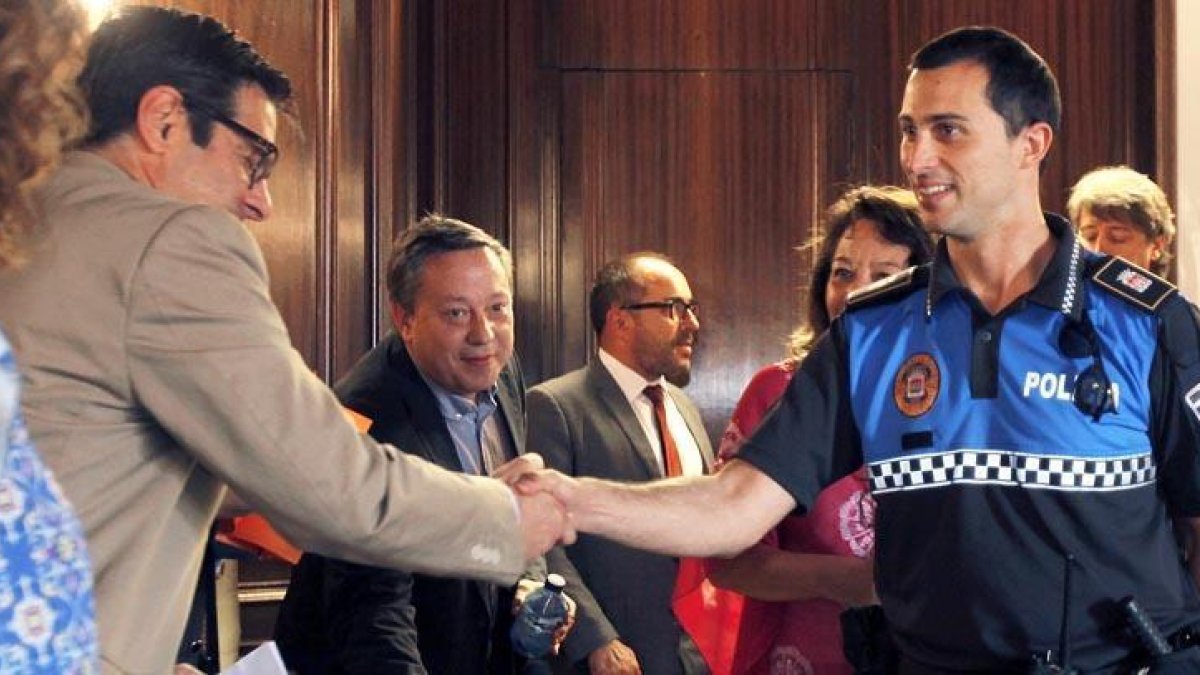 Uno de los policías locales en prácticas, que ayer prestaba servicio en el Consistorio con motivo del pleno, saluda a los concejales.-Mario Tejedor