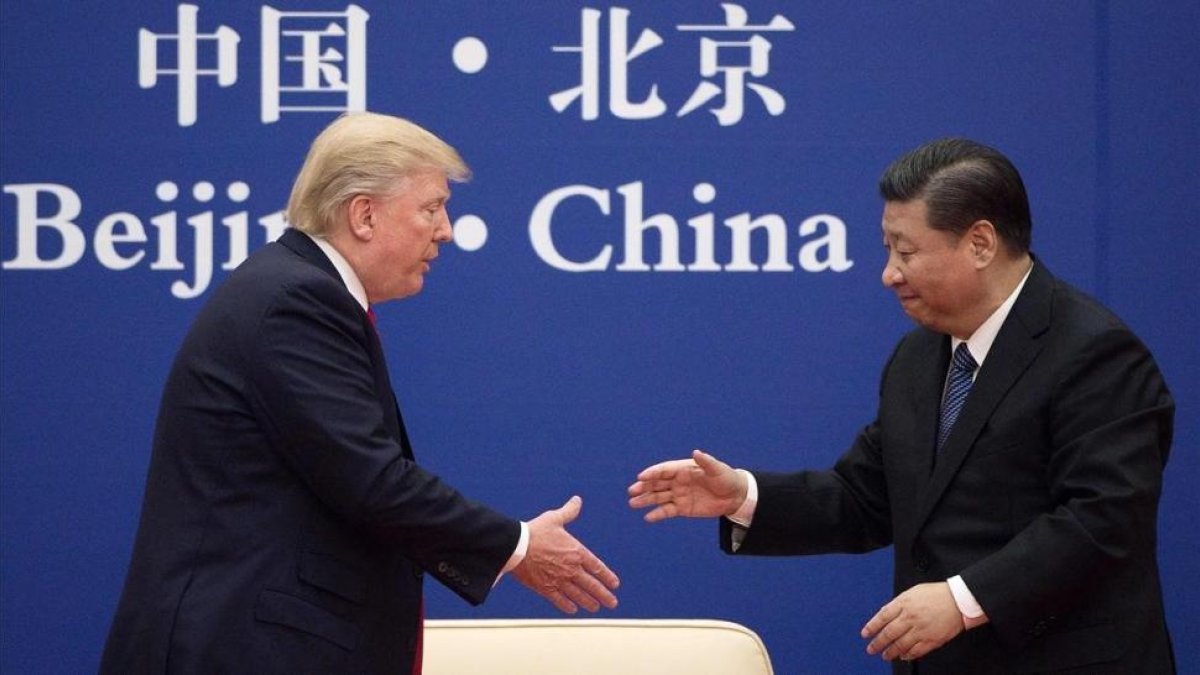 El presidente de China, Xi Jinping, saluda al presidente Donald Trump.-NICOLAS ASFOURI/AFP