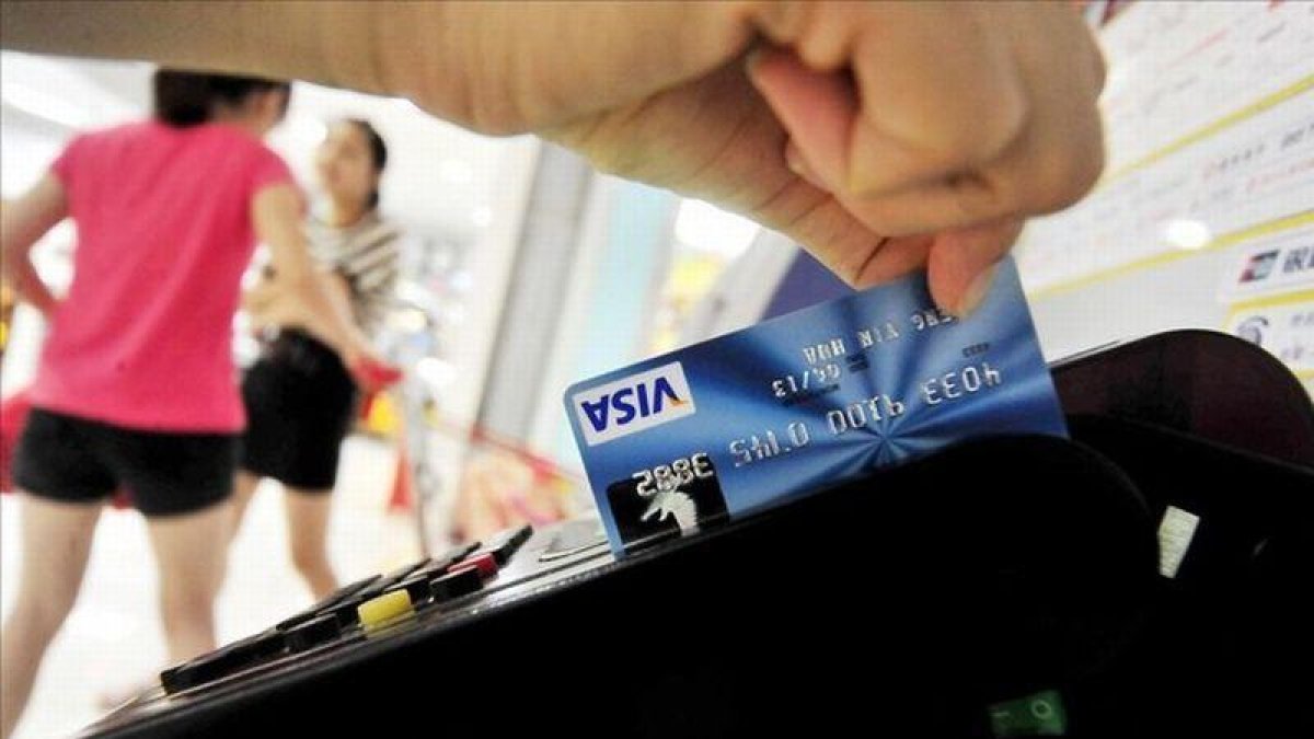 Una mujer usa su tarjeta de crédito.-AFP/FRANKO LEE