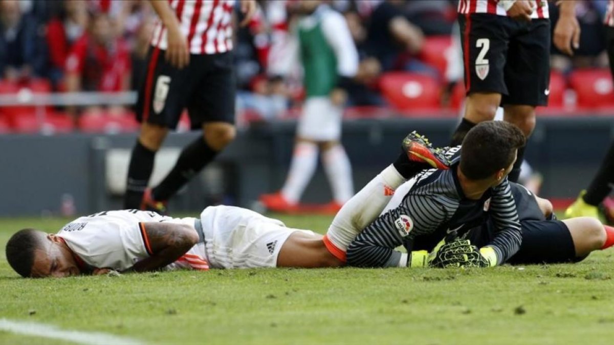 El valencianista Rodrigo, tendido en el césped junto a Kepa, el portero del Athletic, el domingo en San Mamés.-EFE / LUIS TEJIDO