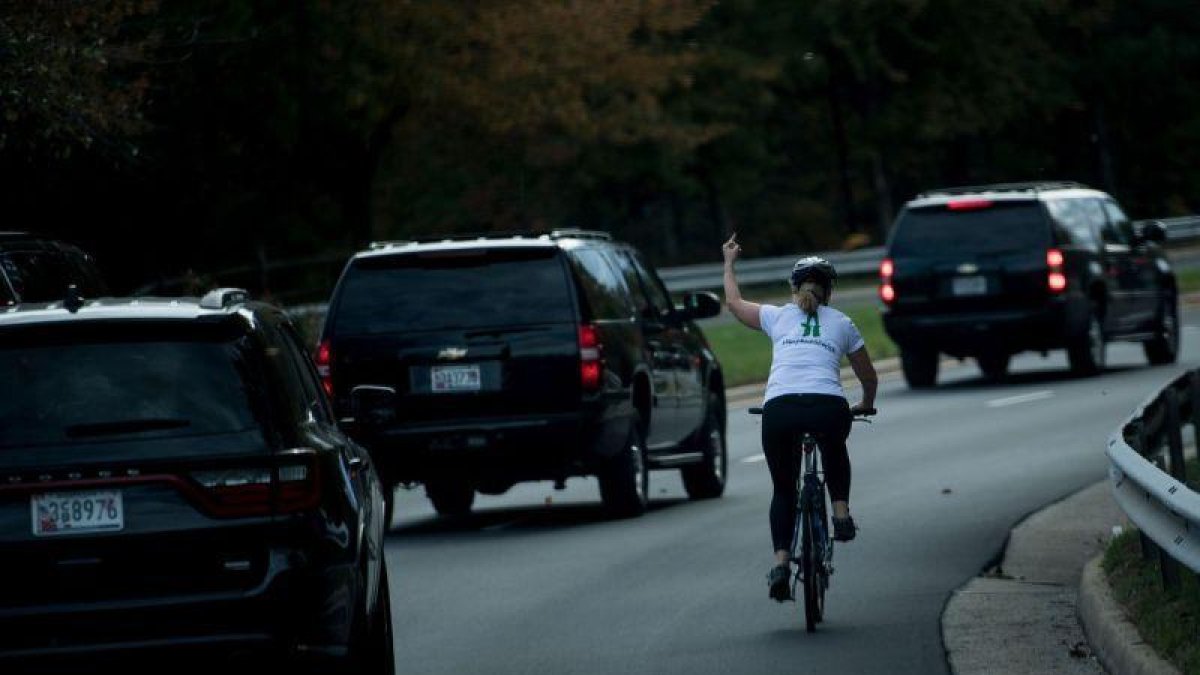 Juli Briskman, en bicicleta, en el momento que le dedicó una peineta a Trump, el 28 de octubre en Washington.-AFP / BRENDAN SMIALOWSKI