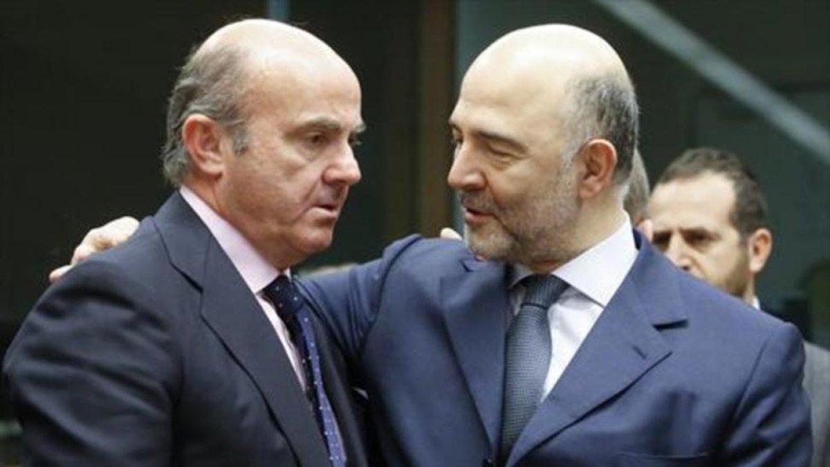 Luis de Guindos con el comisario europeo de Asuntos Económicos, Pierre Moscovici.-EFE / OLIVIER HOSLET