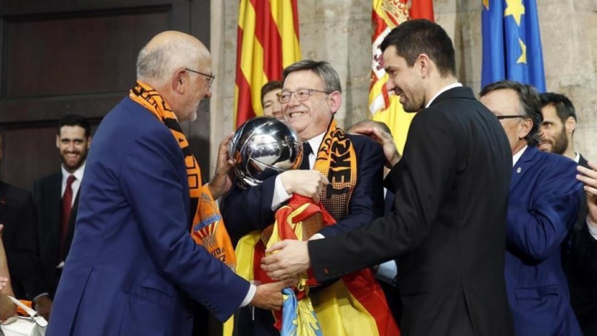 Juan Roig, propietario del club, y Rafa Martínez, capitán del equipo, ofrecen el trofeo a Ximo Puig, presidente de la Generalitat valenciana-EFE / KAI FORSTERLING