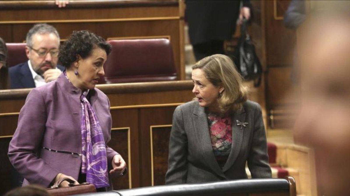 La ministra de Trabajo, Magdalena Valerio, conversa con la titular de Economía, Nadia Calviño, en el Congreso de los Diputados.-DAVID CASTRO