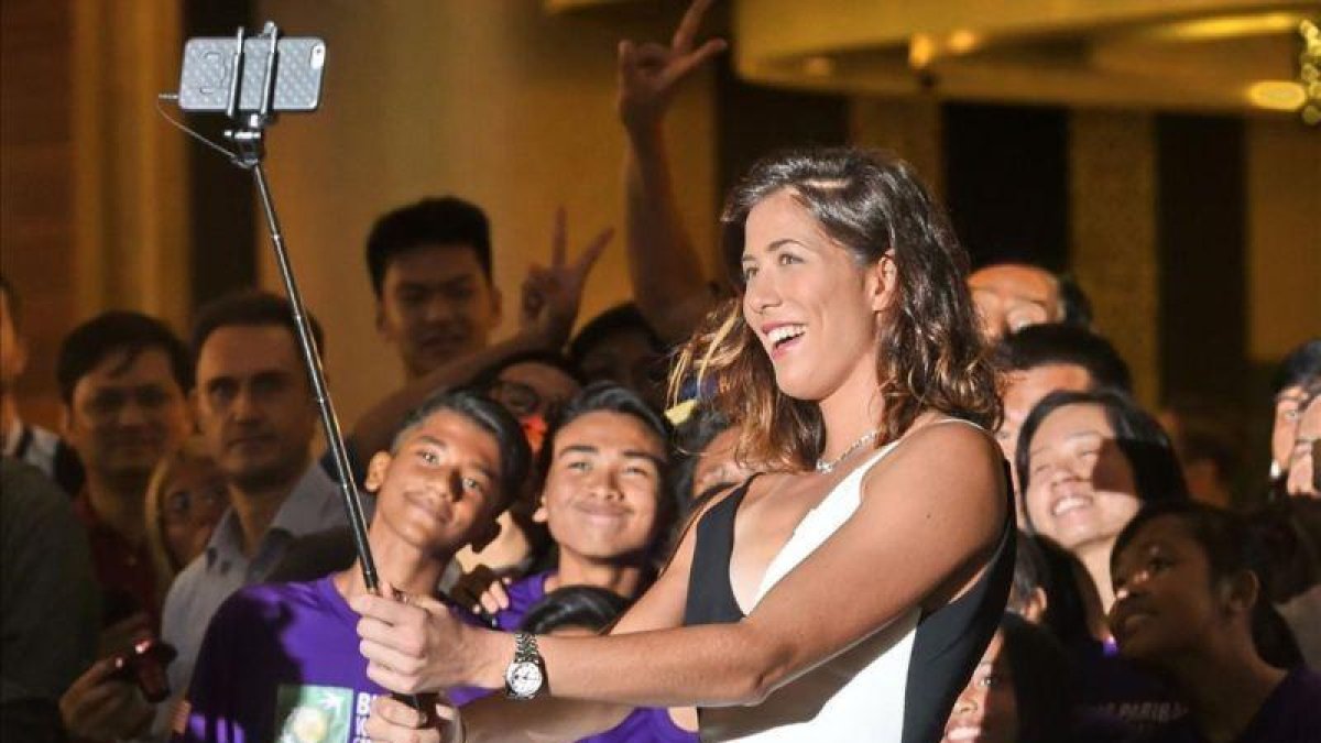 Garbiñe Muguruza se hace un selfi durante el sorteo del cuadro del Masters femenino, en Singapur.-AFP / ROSLAN RAHMAN