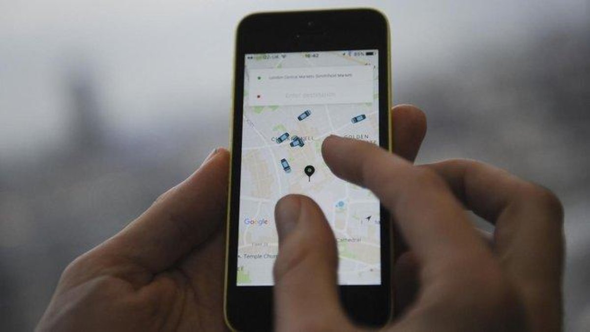 Un usuario de Uber utilizando la aplicación.-AFP / DANIEL SORABJI