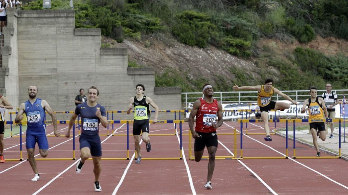 David José Pineda, de rojo con el dorsal 207, encara la recta final del 400 vallas, prueba en la que logró una destacada medalla de plata. Se impuso Javier Delgado, dorsal 140.-Luis Ángel Tejedor