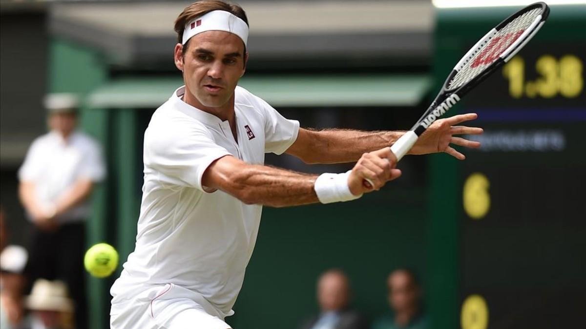 Federer devuelve un revés, en su partido con Mannarino en Wimbledon.-AFP / OLI SCARFF