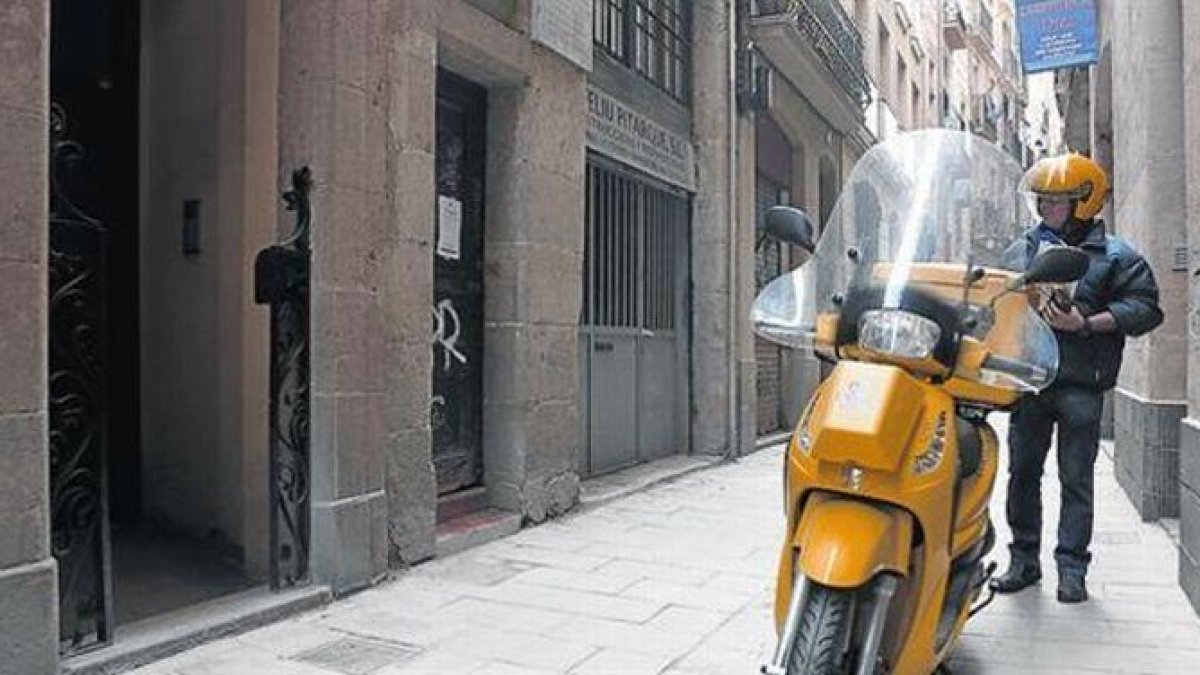 Un cartero de la calle de Sant Pere Mitjà, a punto de entregar un carta.-FERRAN NADEU