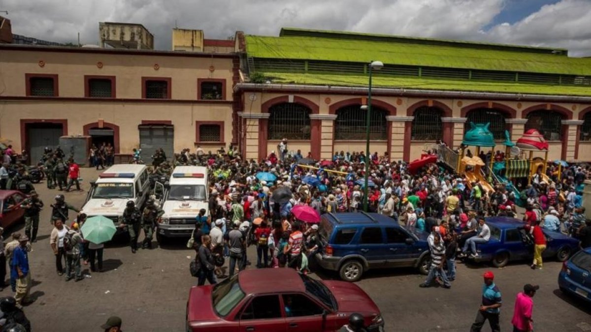Un grupo de personas hace fila para poder comprar alimentos el martes en Caracas.-EFE / MIGUEL GUTIERREZ