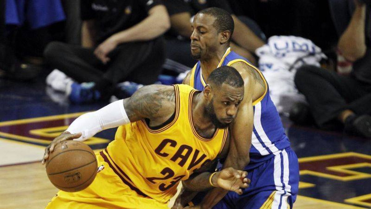 El jugador de los Warriors de Golden State Andre Iguodala (dcha) intenta evitar la entrada de LeBron James (izq), de los Cavaliers de Cleveland, durante el tercer encuentro de las finales de la NBA.-Foto: EFE