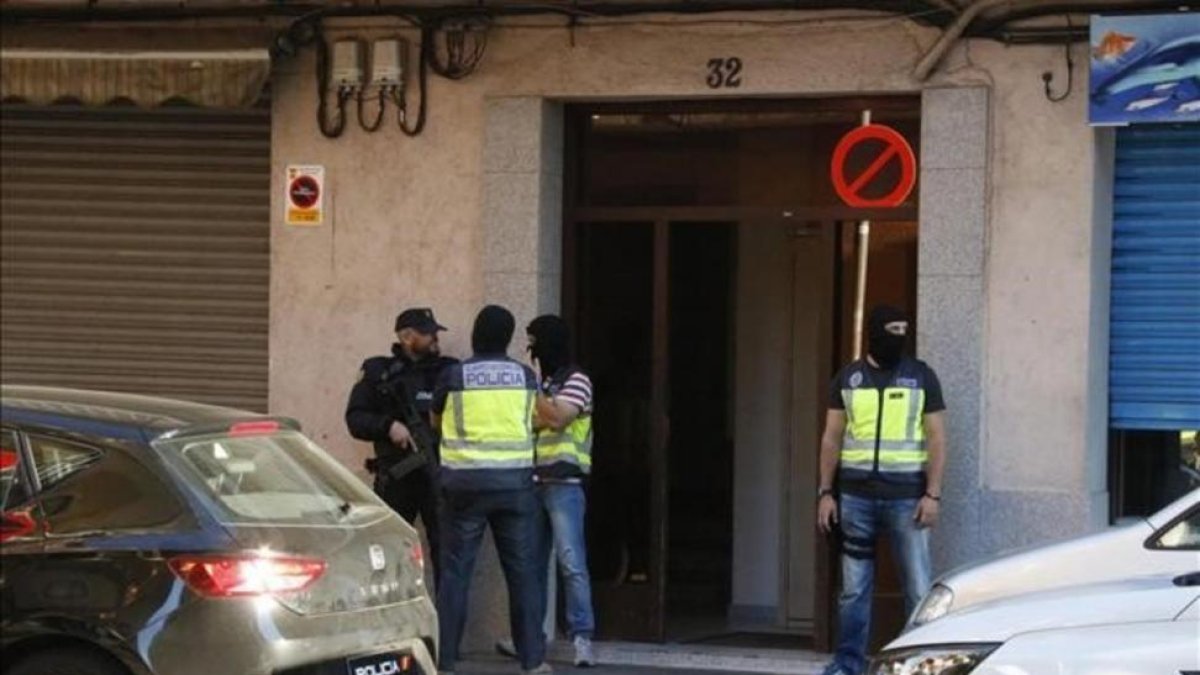 Agentes de la Policía Nacional montan guardia en la puerta del domicilio de uno de los presuntos yihadistas detenidos el pasado septiembre en Canovelles (Barcelona).-JORDI PUJOLAR