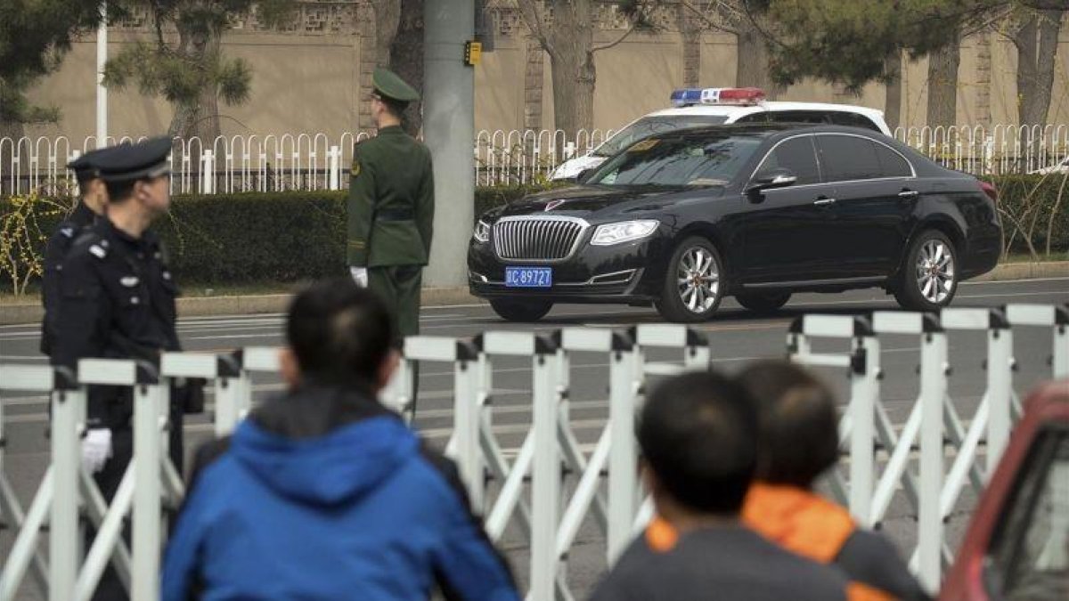 Policías y funcionarios de seguridad montan guardia en una carretera cercana a la residencia oficial para invitados gubernamentales de Diaoyutai, en Pekín, el 27 de marzo.-AP / MARK SCHIEFELBEIN