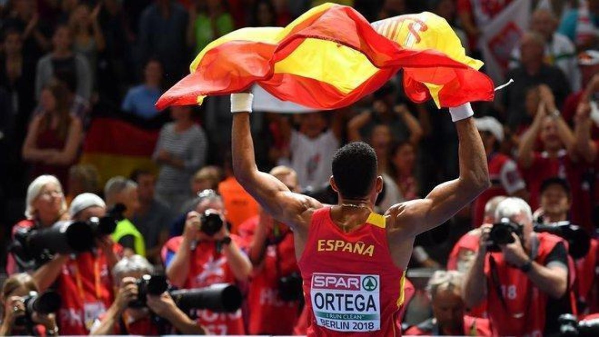 Orlando Ortega, con la bandera española tras quedar tercero en el Europeo de Berlín, el año pasado.-AFP / ANDREJ ISAKOVIC