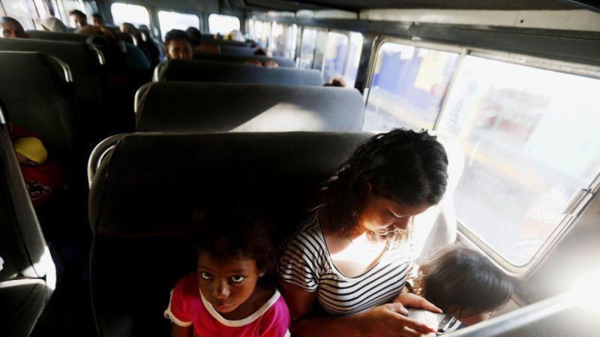 María llora junto a sus dos hijas en el autobús que las regresará voluntariamente a Honduras. María estuvo en la caravana de migrantes hondureños por más de una semana, pero el cansancio y la incertidumbre hizo que decidiera regresar.-EFE/ESTEBAN BIBA