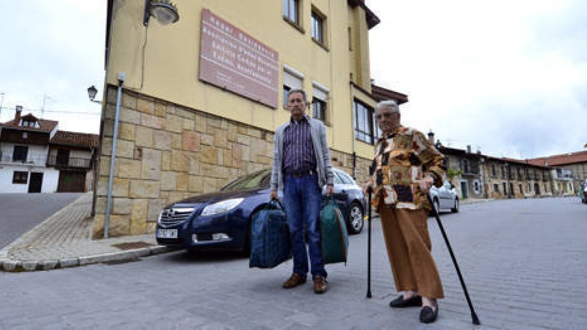 Inés Herrero y su hijo Gustavo salen con las maletas de la residencia. / ÁLVARO MARTÍNEZ-