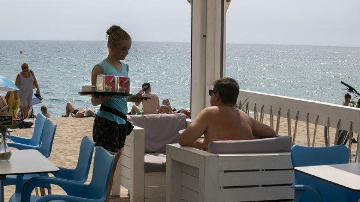 Una camarera en un chiringuito de playa trabajando durante el verano.-MAITE CRUZ