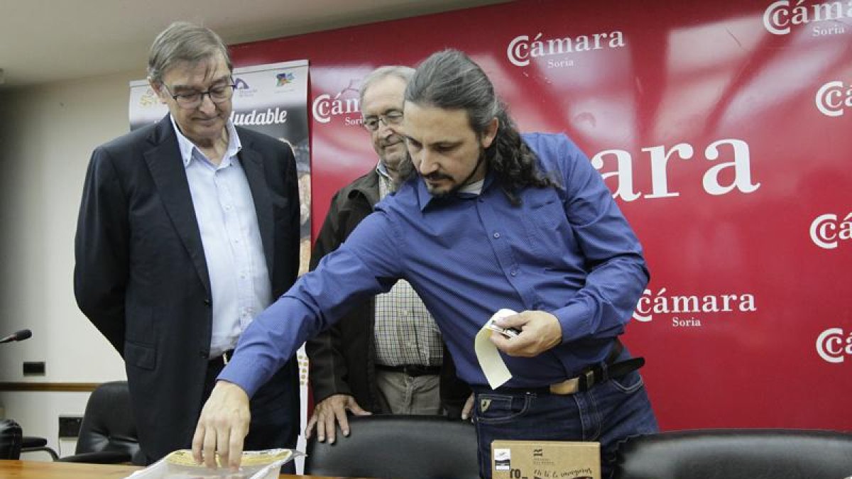 Samuel Moreno y Amador Frías observan cómo Darío Lara pega una de las primeras etiquetas de Gourosma.-LUIS ÁNGEL TEJEDOR