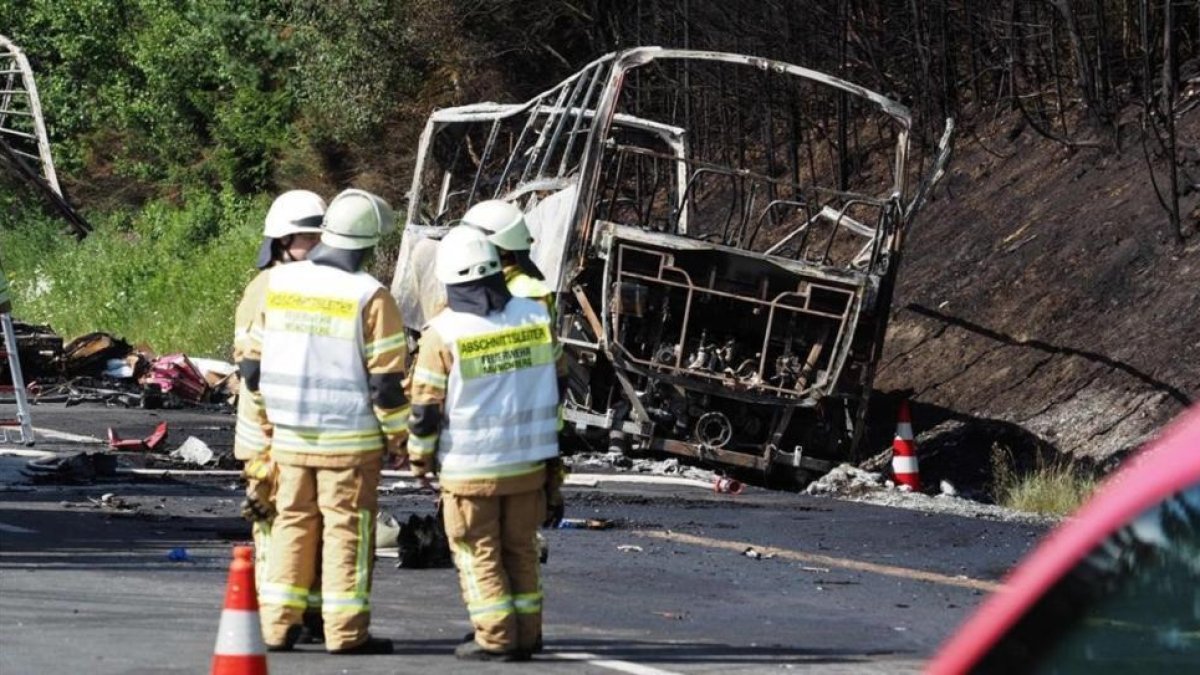 Restos calcinados del autocar.-AFP