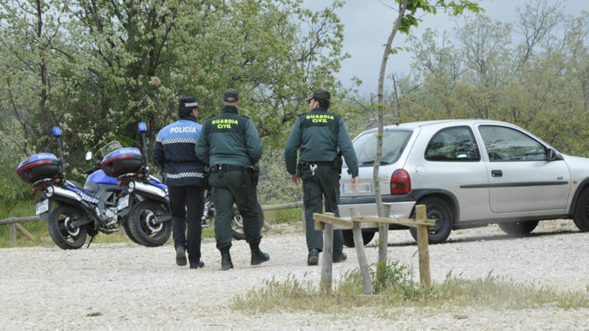 Agentes de la Guardia Civil se dirigen a un turismo, en una imagen del sábado. / VALENTÍN GUISANDE-