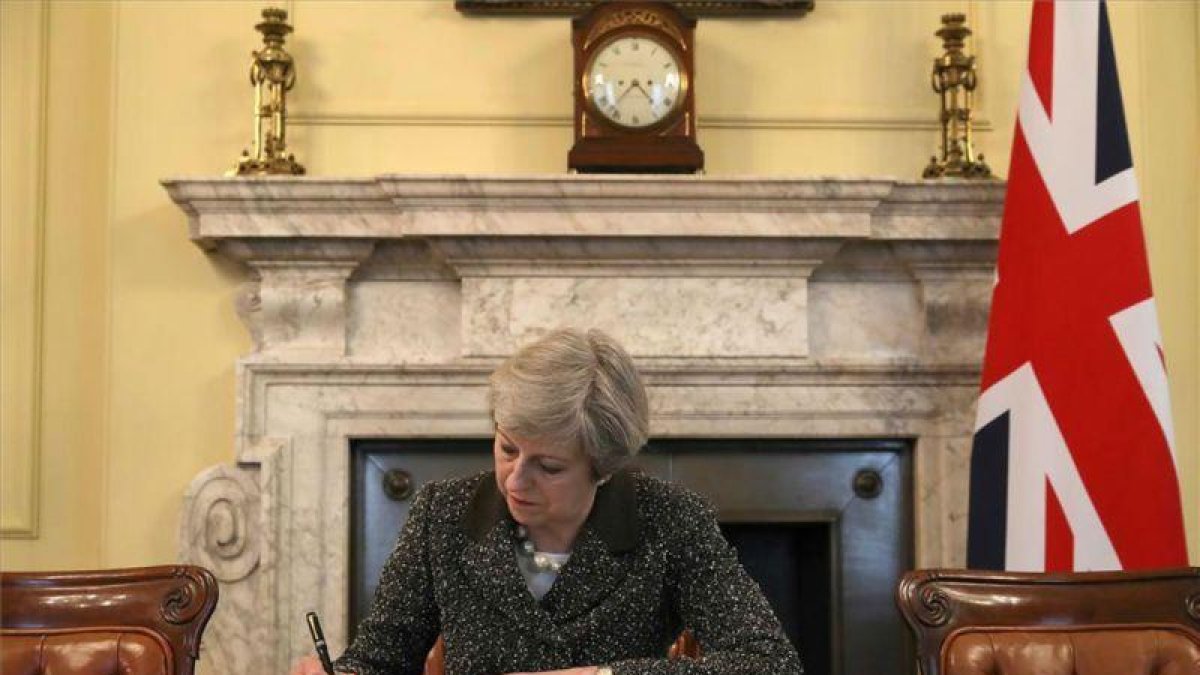 La primera ministra británica, Theresa May, firma la carta con la que arranca el 'brexit'.-REUTERS