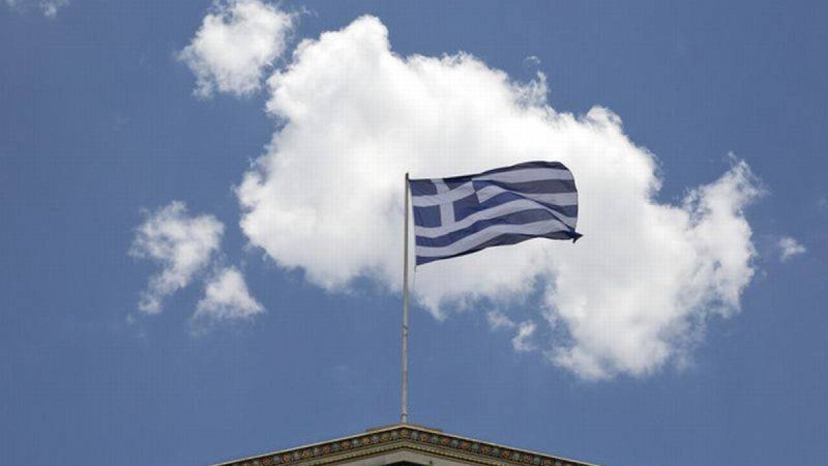 La bandera griega ondea en la Academia de Atenas.-Foto: AP
