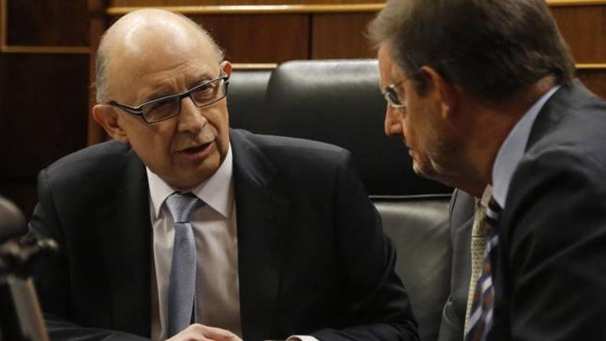 El ministro de Hacienda, Cristóbal Montoro, conversa con el presidente del Gobierno, Mariano Rajoy, este martes durante el debate sobre los Presupuestos en el Congreso.-Foto: AGUSTÍN CATALÁN