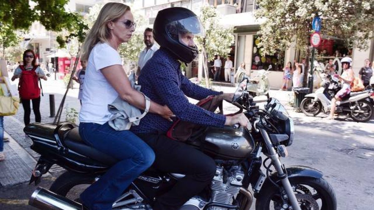 El ya exministro de Finanzas griego, Yanis Varoufakis, y su mujer, Danae Stratou, encima de una moto a la puerta de su casa, en Atenas.-Foto: AFP / LOUISA GOULIAMAKI