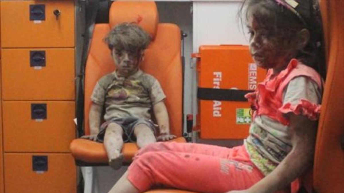 El pequeño Omran, de 5 años, junto a su hermana, tras ser rescatados de un edificio bombardeado el miércoles en Alepo.-REUTERS