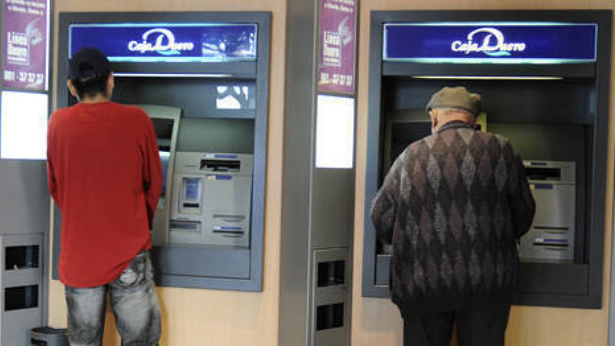 Dos personas sacan dinero de un cajero de la capital. / V.G.-