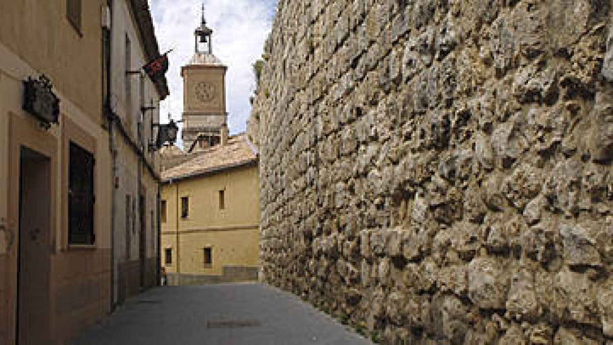 Una calle de la localidad de Almazán dónde puede apreciarse el estado actual de la muralla. / VALENTÍN GUISANDE-
