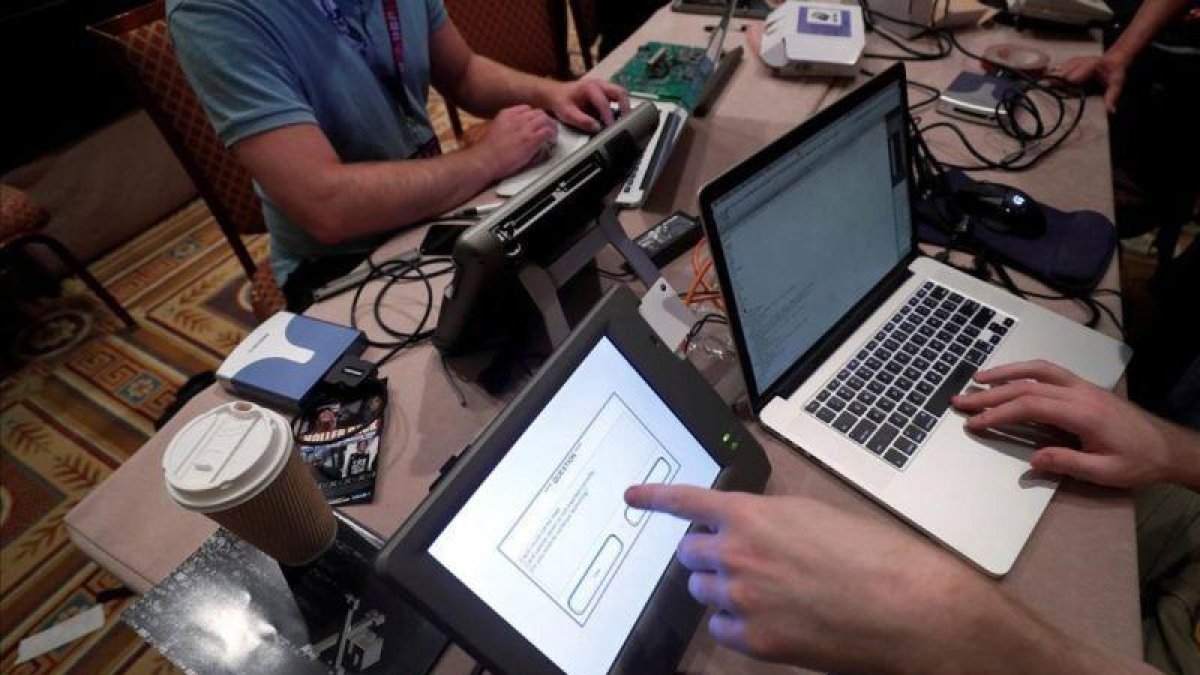 Unos hackers intentan acceder a los datos de una máquina de votación durante una convención en Las Vegas.-STEVE MARCUS (REUTERS)