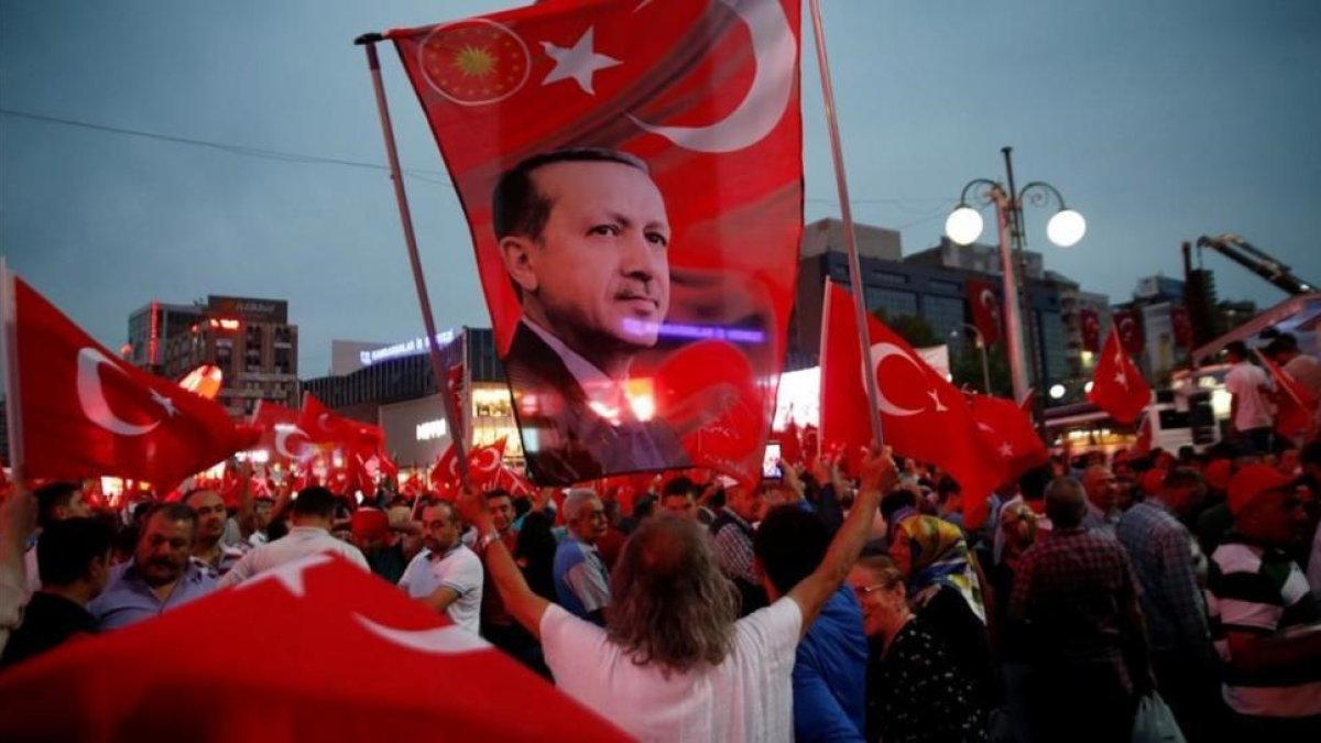 Un seguidor de Erdogan sostiene una bandera con una imagen del presidente turco, en una marcha progubernamental, en Ankara, el 20 de julio.-REUTERS / BAZ RATNER