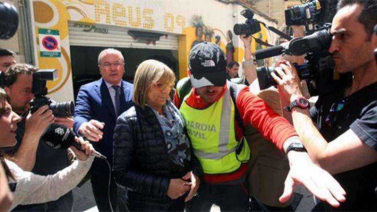 La primera teniente de alcalde del Ayuntamiento de Reus, Teresa Gomis, acompañada del alcalde de la localidad, Carles Pellicer (CiU) (izquierda), sale detenida por la puerta de atrás del ayuntamiento, el martes 28 de abril.-Foto: EFE / JAUME SELLART
