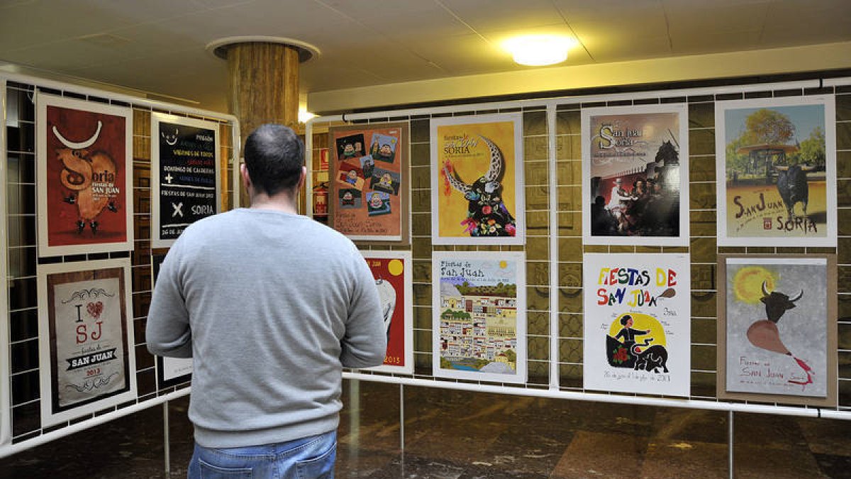 Un ciudadano observa los carteles de San Juan que se exhiben en el patio de columnas del Ayuntamiento. / REPORTAJE GRÁFICO: VALENTÍN GUISANDE-